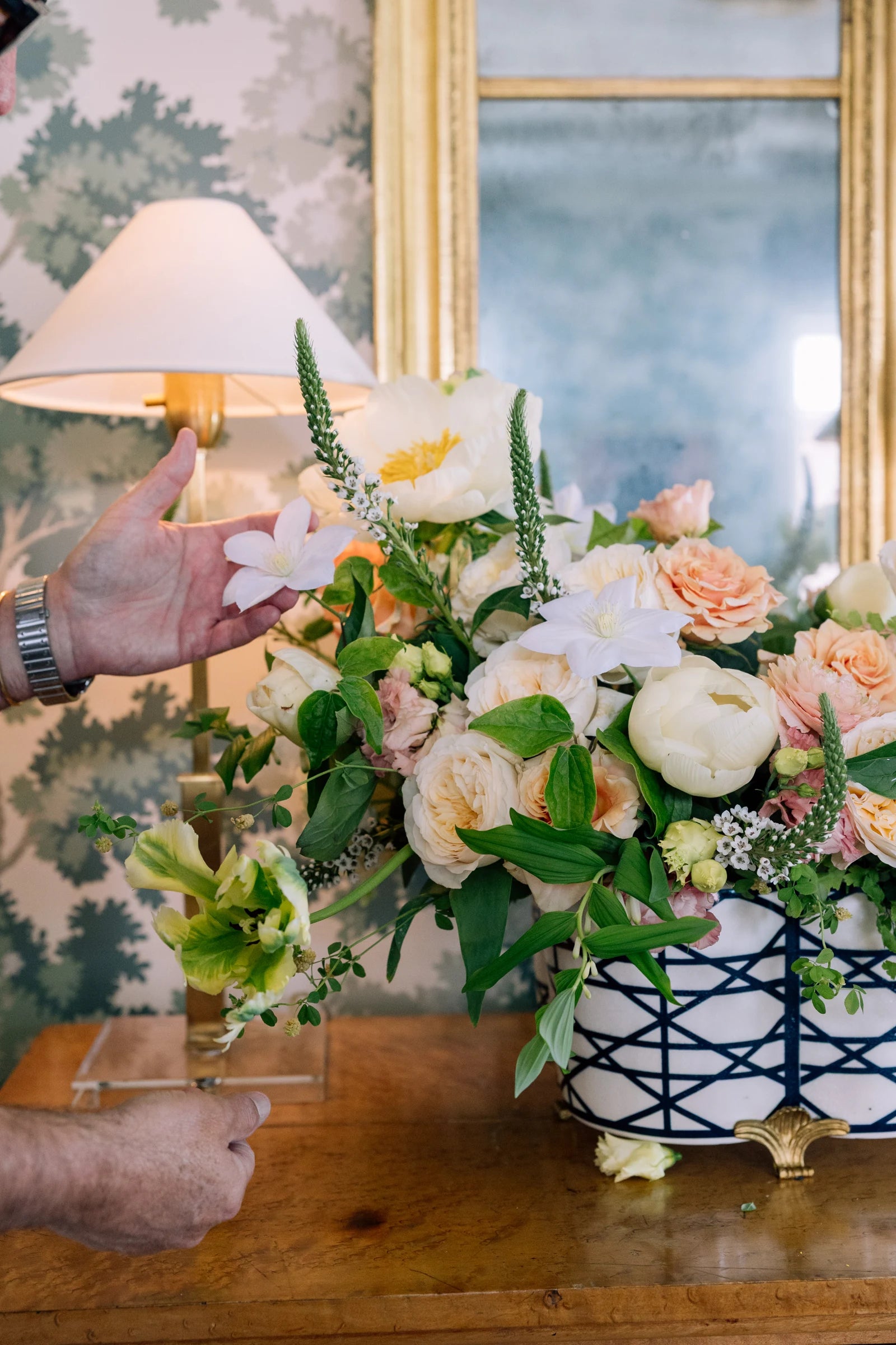 Peach and white flowers arranged in a patterned vase