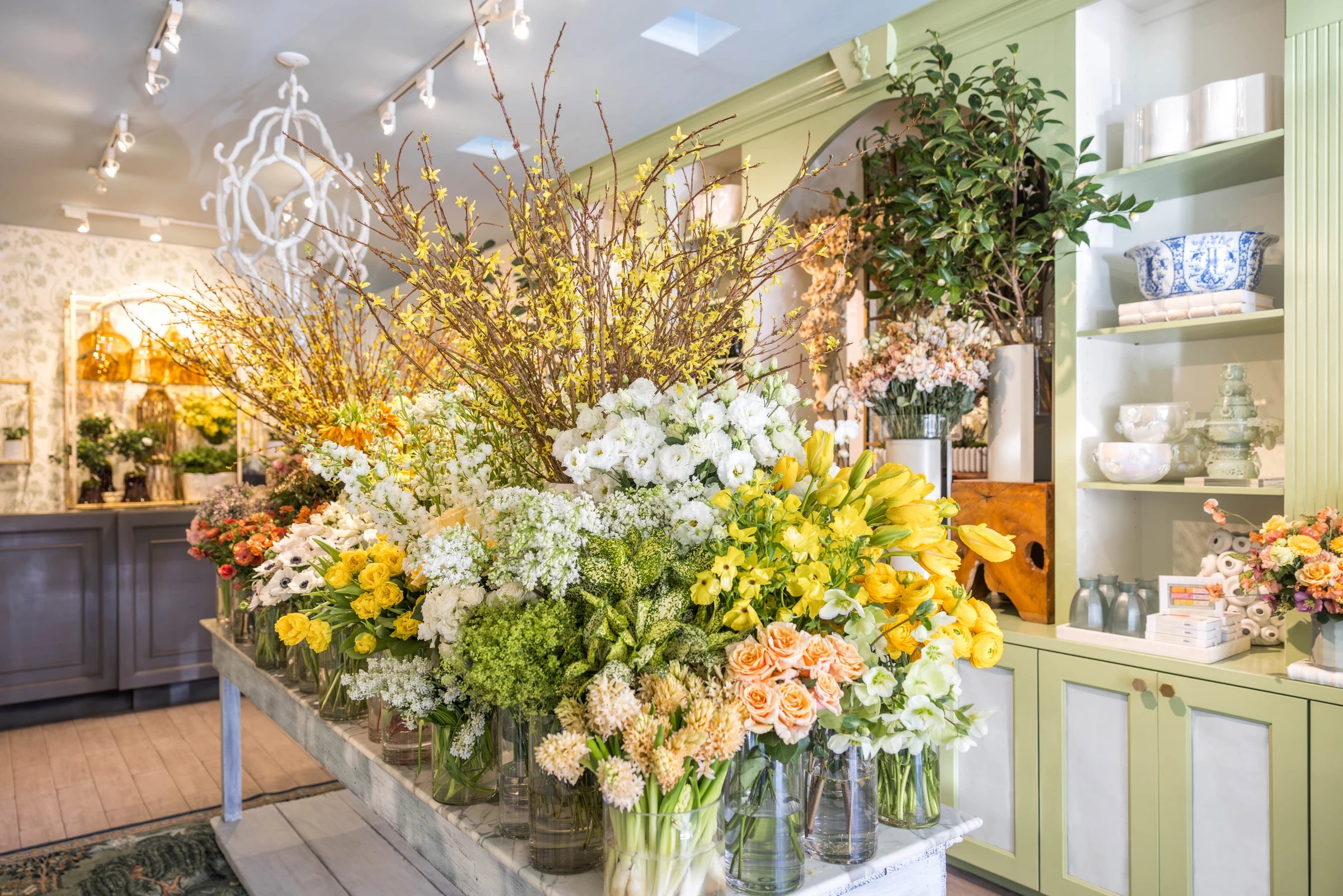 Seasonal flowers displayed beneath the shop chandeliers